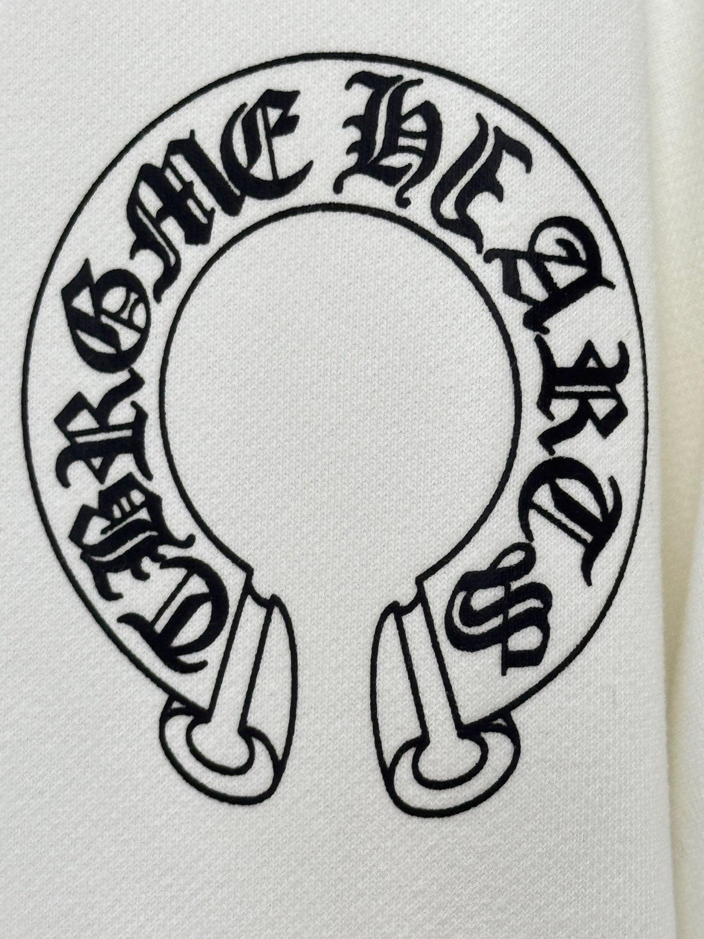 White hoodie fabric close-up of large circular graphic logo in black