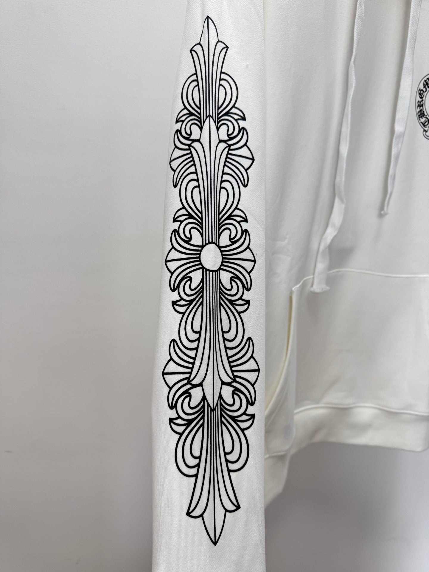 White hoodie sleeve with vertical fleur de lis line-art print
