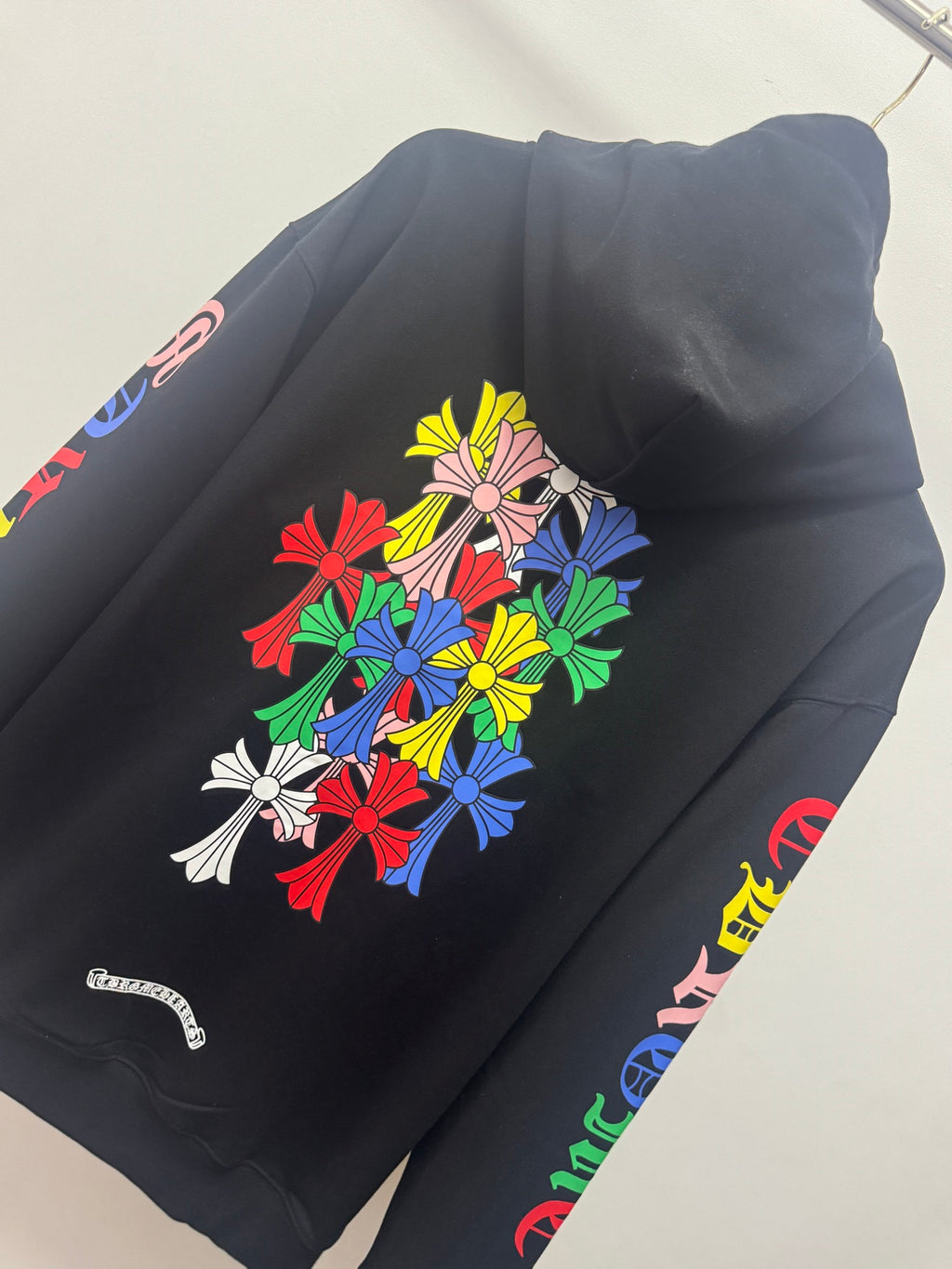 Black hoodie back with colorful floral bouquet graphic and side sleeve text