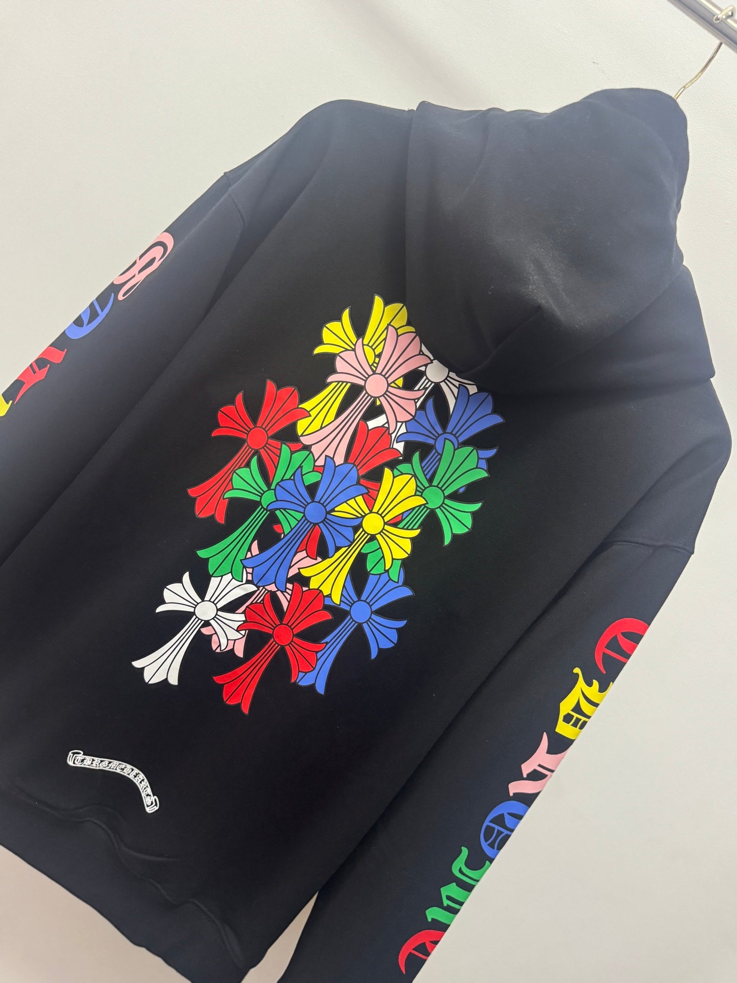 Black hoodie back with colorful floral bouquet graphic and side sleeve text