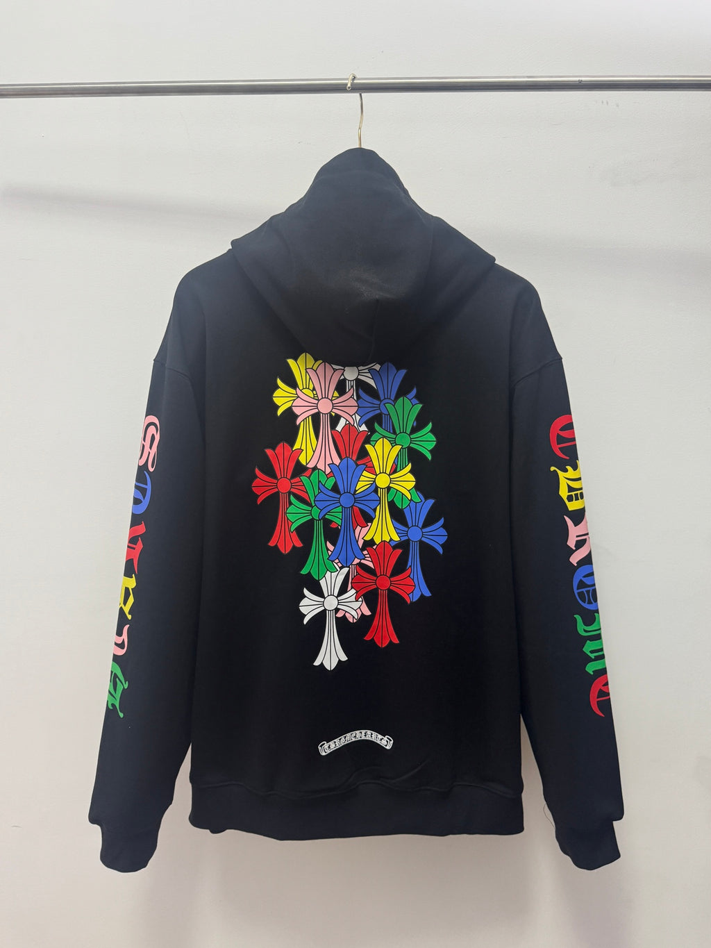 Black back hoodie with large colorful floral bouquet graphic and printed sleeve text