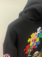Black hoodie close-up with floral print on sleeve and colorful hood graphic