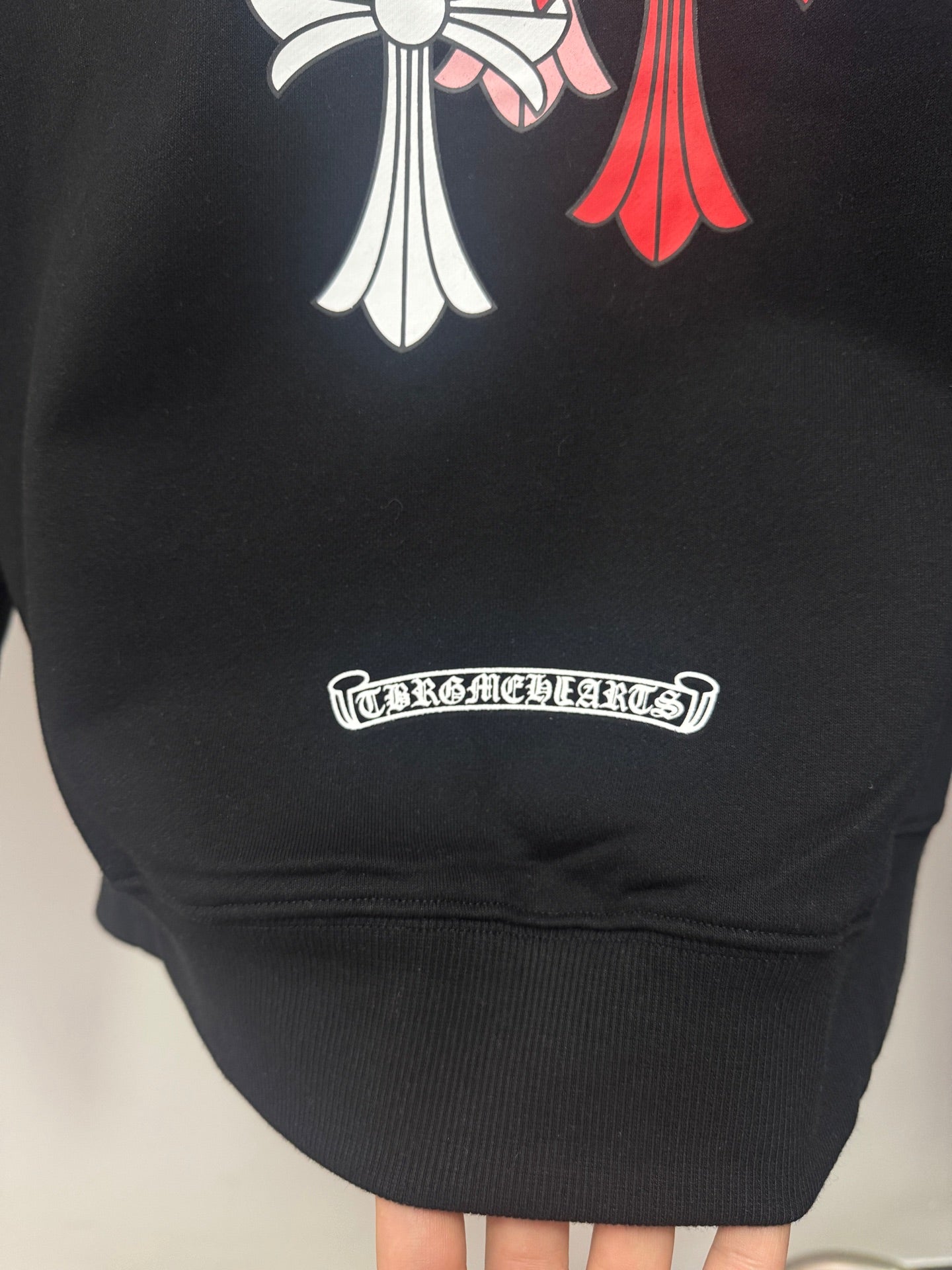 Black hoodie front lower area with rectangular brand logo patch