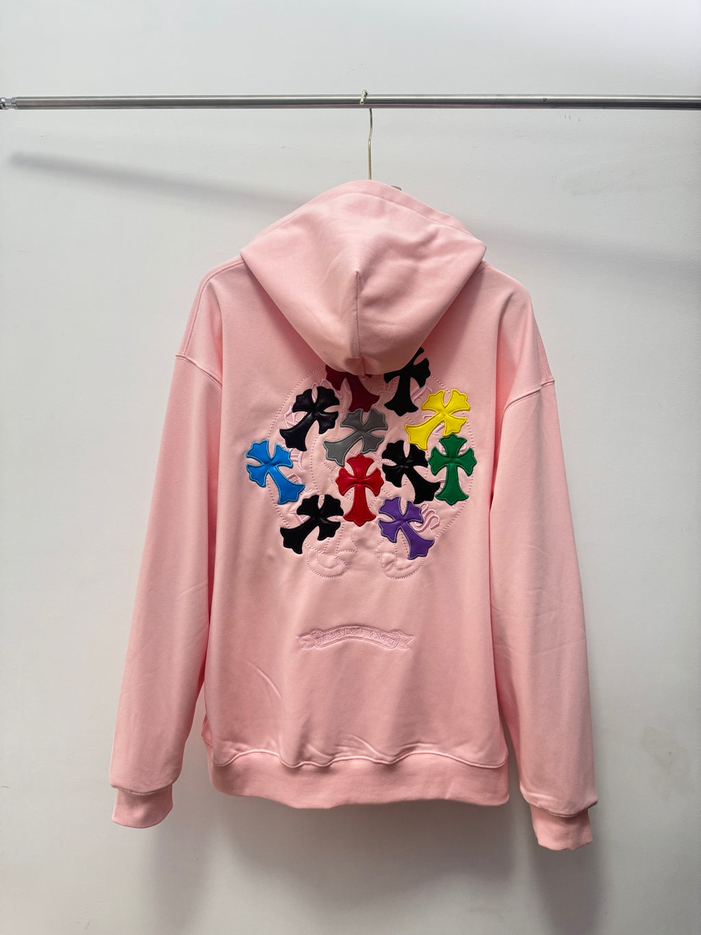 Pink pullover hoodie with hood and multicolor floral embroidery on the back