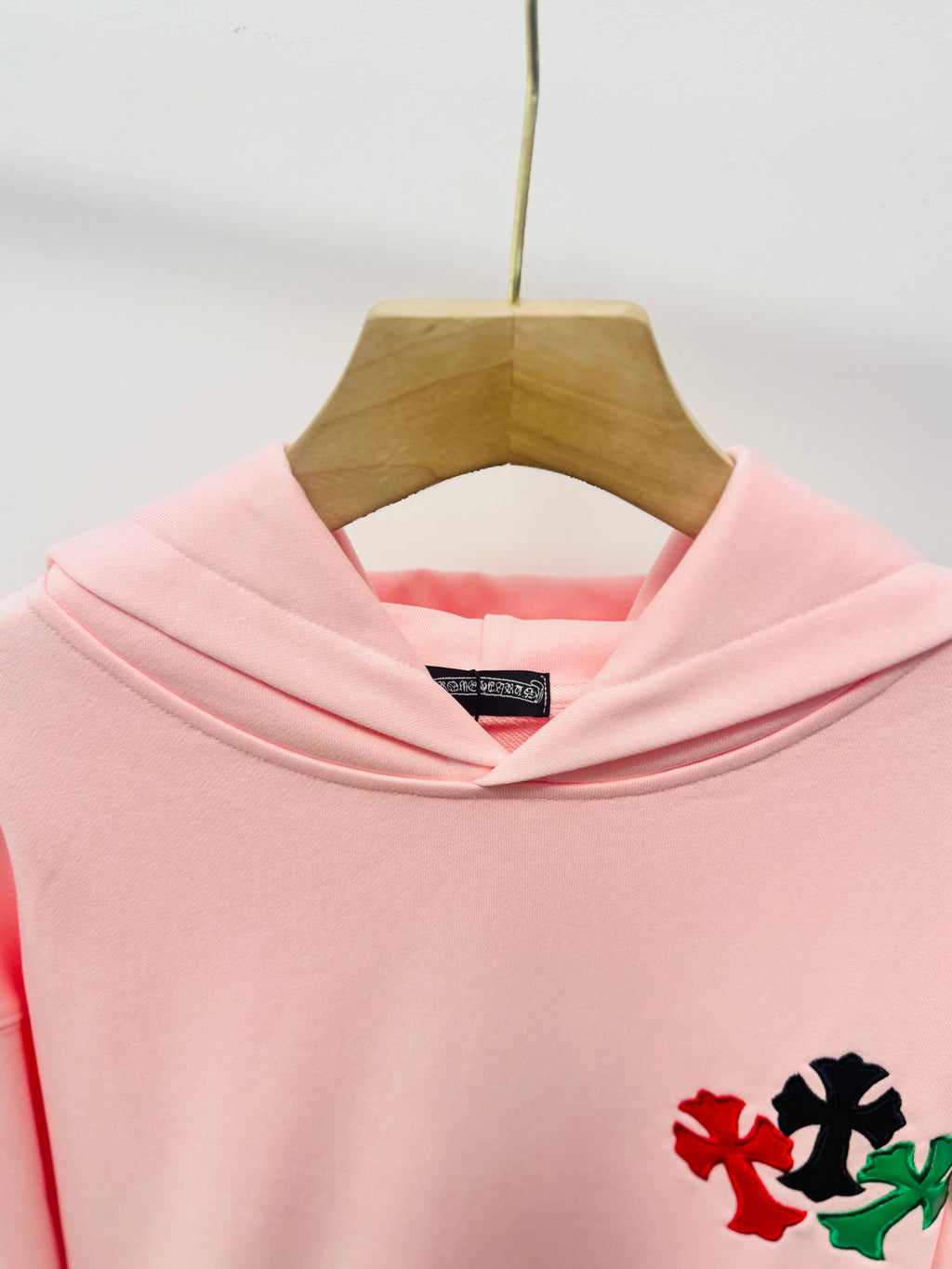 Pink hoodie with hood and embroidered floral detail on the chest
