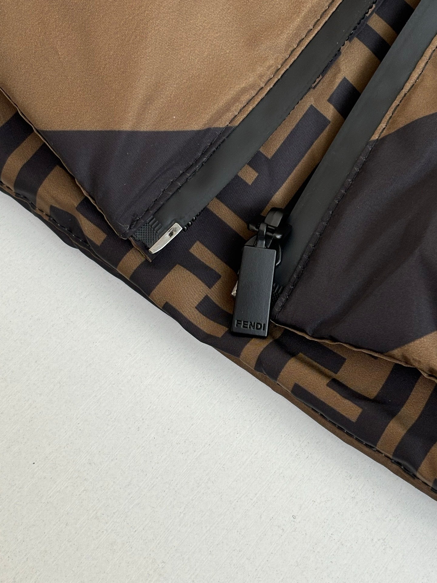 Fendi padded jacket hem with branded label and zipper area close-up