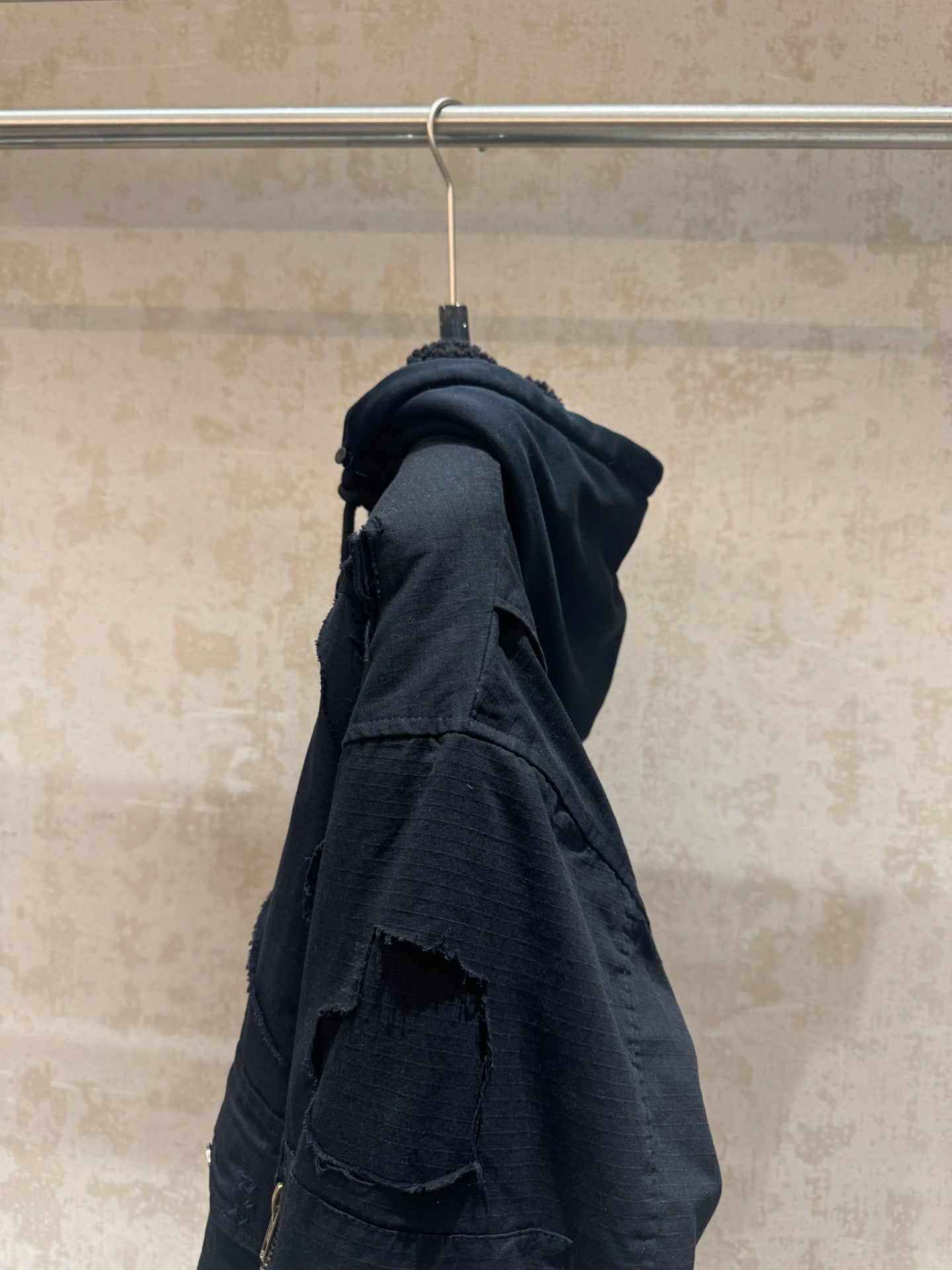 Balenciaga long hooded jacket side view, dark with cargo pocket and seam details
