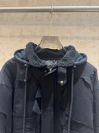 Balenciaga long hooded jacket close-up, dark with shearling-lined hood and snap buttons