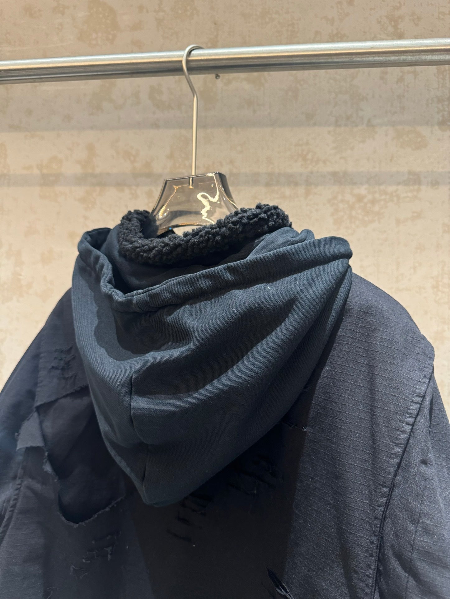 Balenciaga long hooded jacket back view, dark with shearling-lined hood