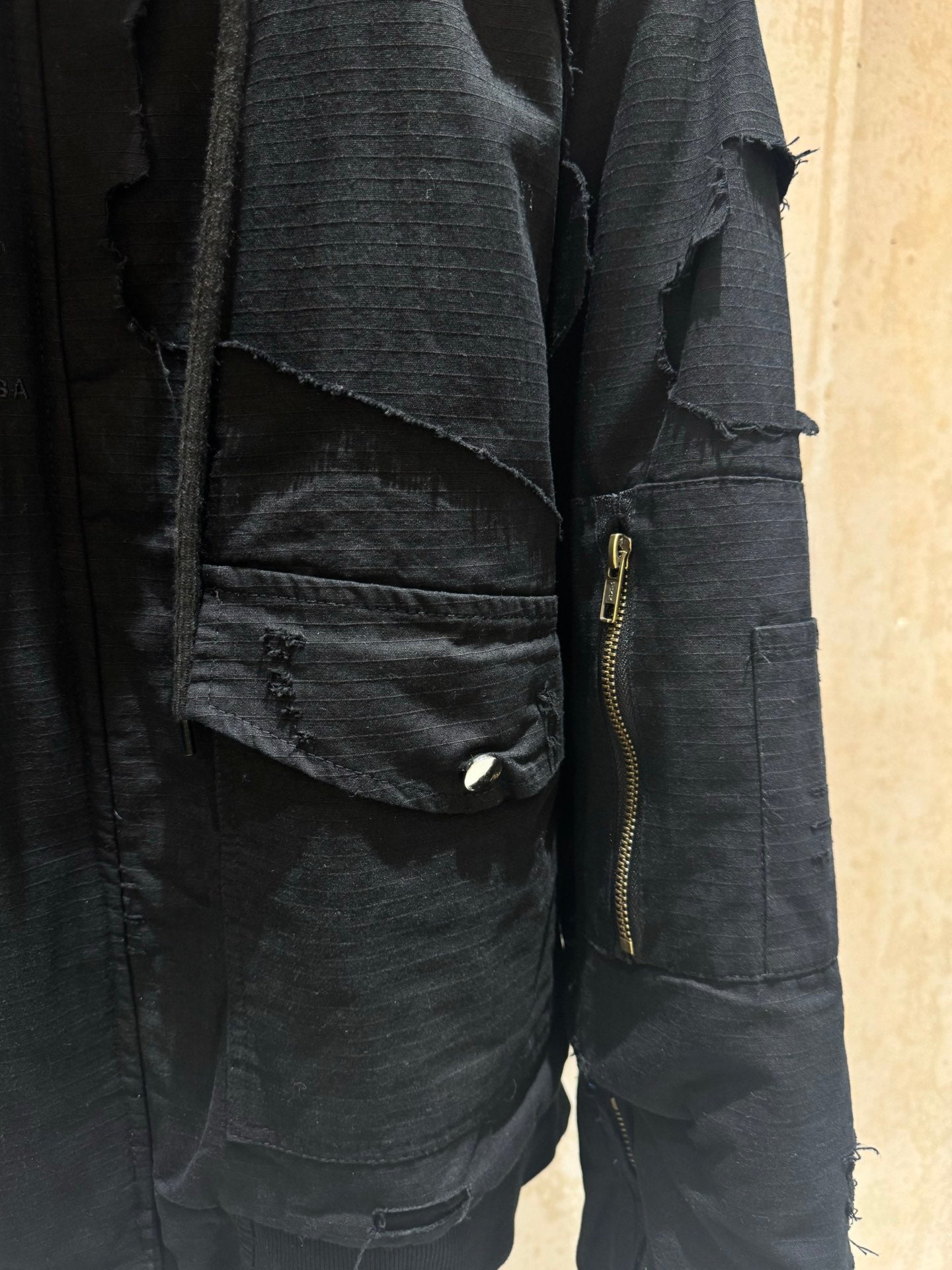 Balenciaga long jacket detail, dark zip pocket with gold-toned zipper pull