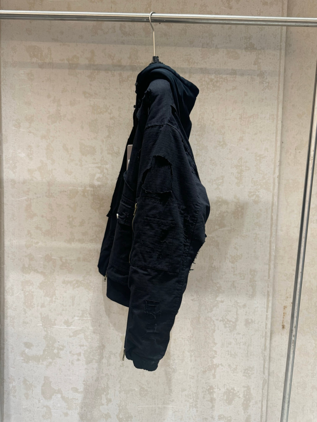 Balenciaga long jacket, dark, side profile with hood and cargo-style pocket