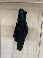 Balenciaga long jacket, dark, side profile with hood and cargo-style pocket
