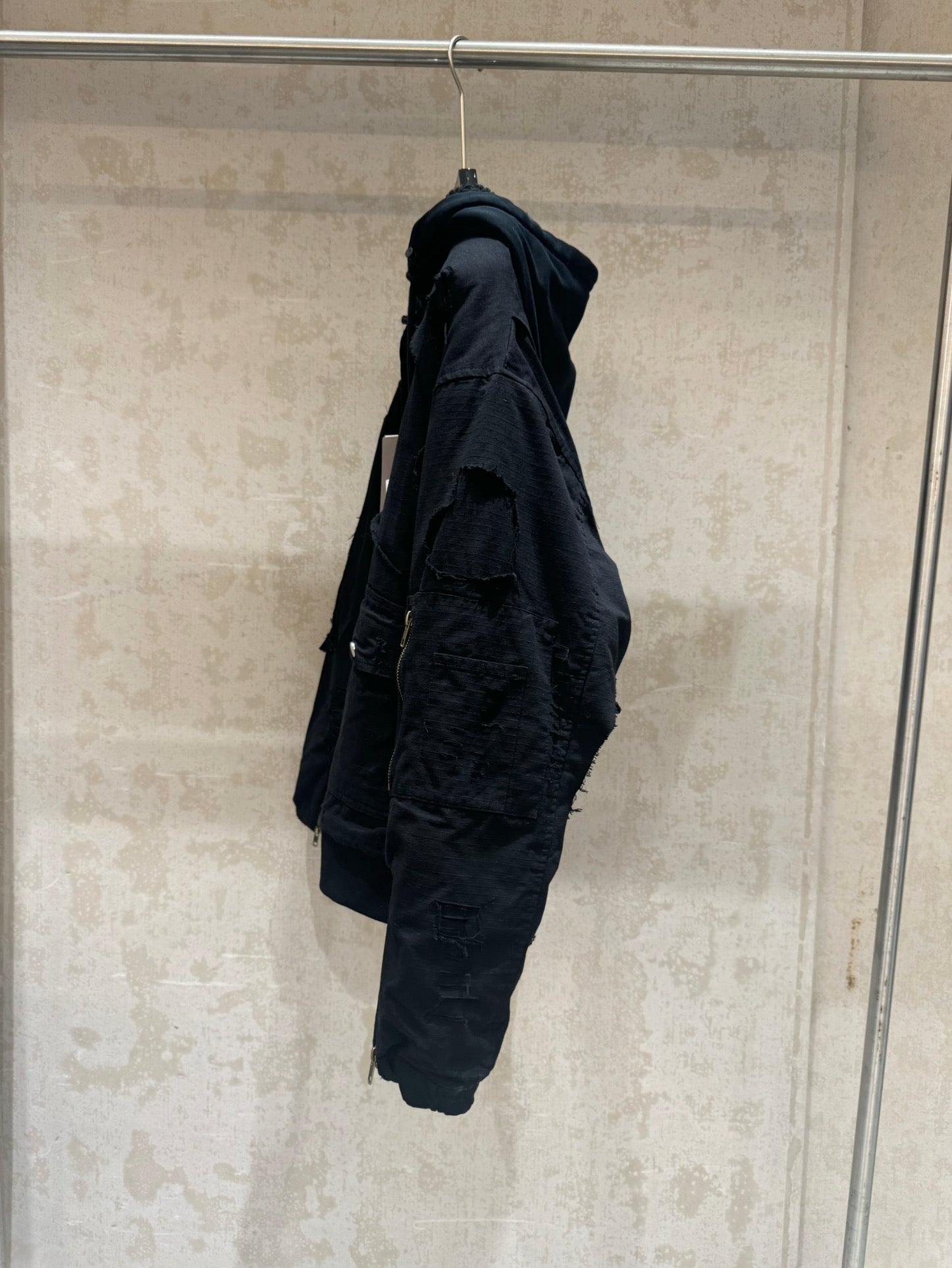 Balenciaga long jacket, dark, side profile with hood and cargo-style pocket