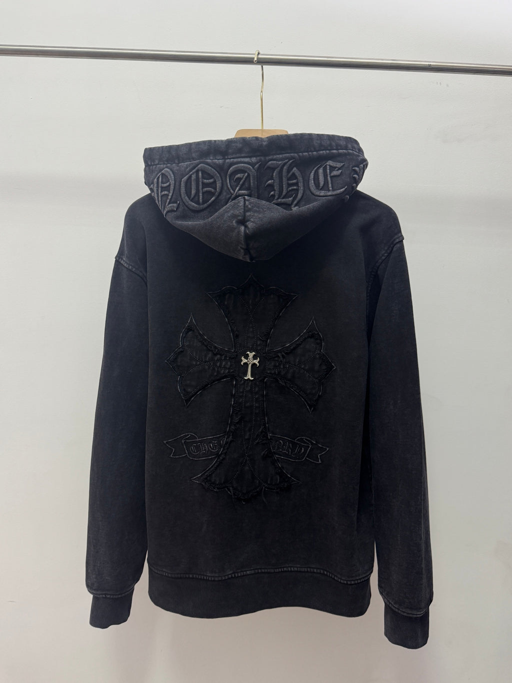 Dark zip-up hoodie, back view with hood graphic and embroidered center cross design.