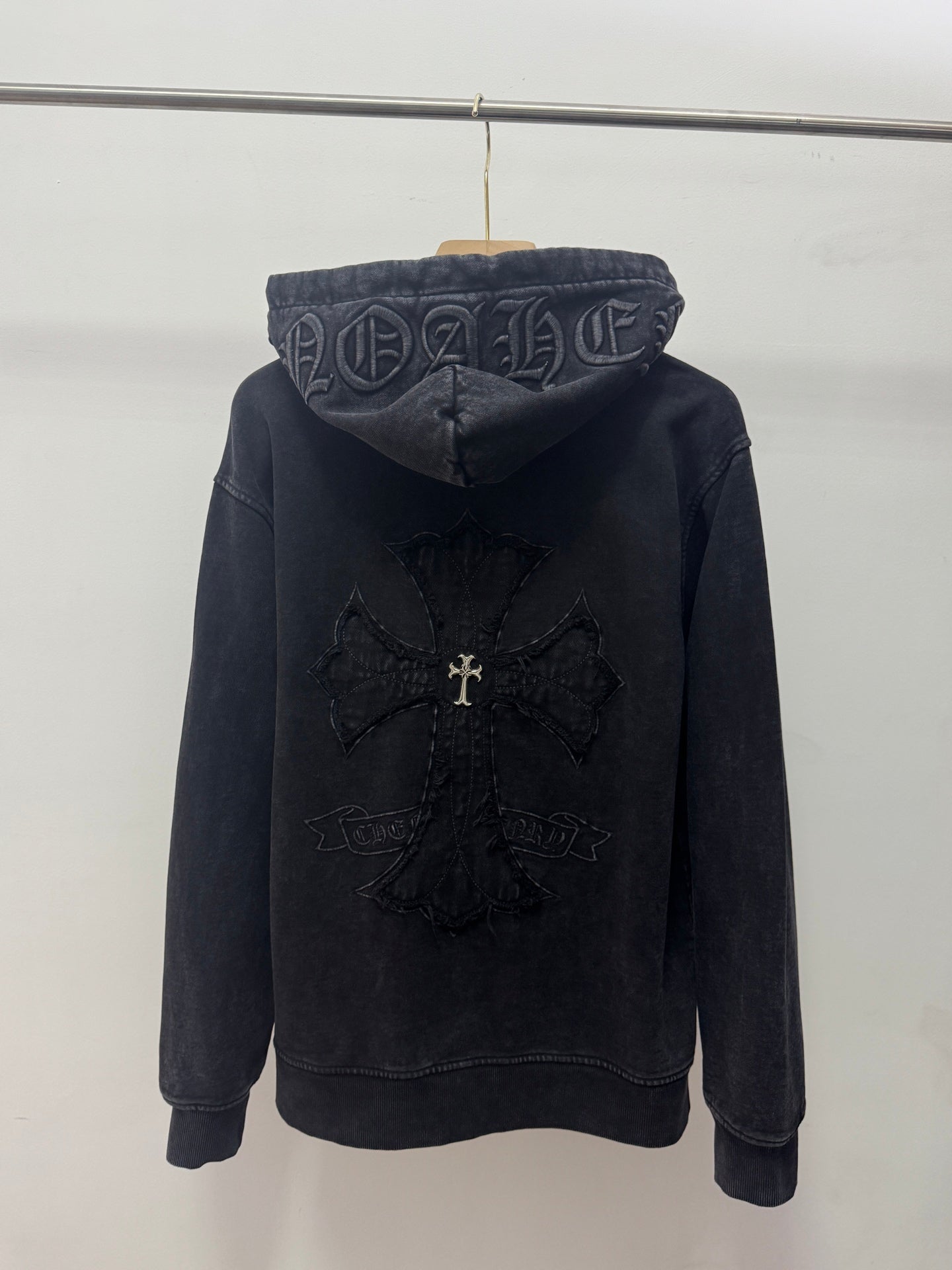 Dark zip-up hoodie, back view with hood graphic and embroidered center cross design.