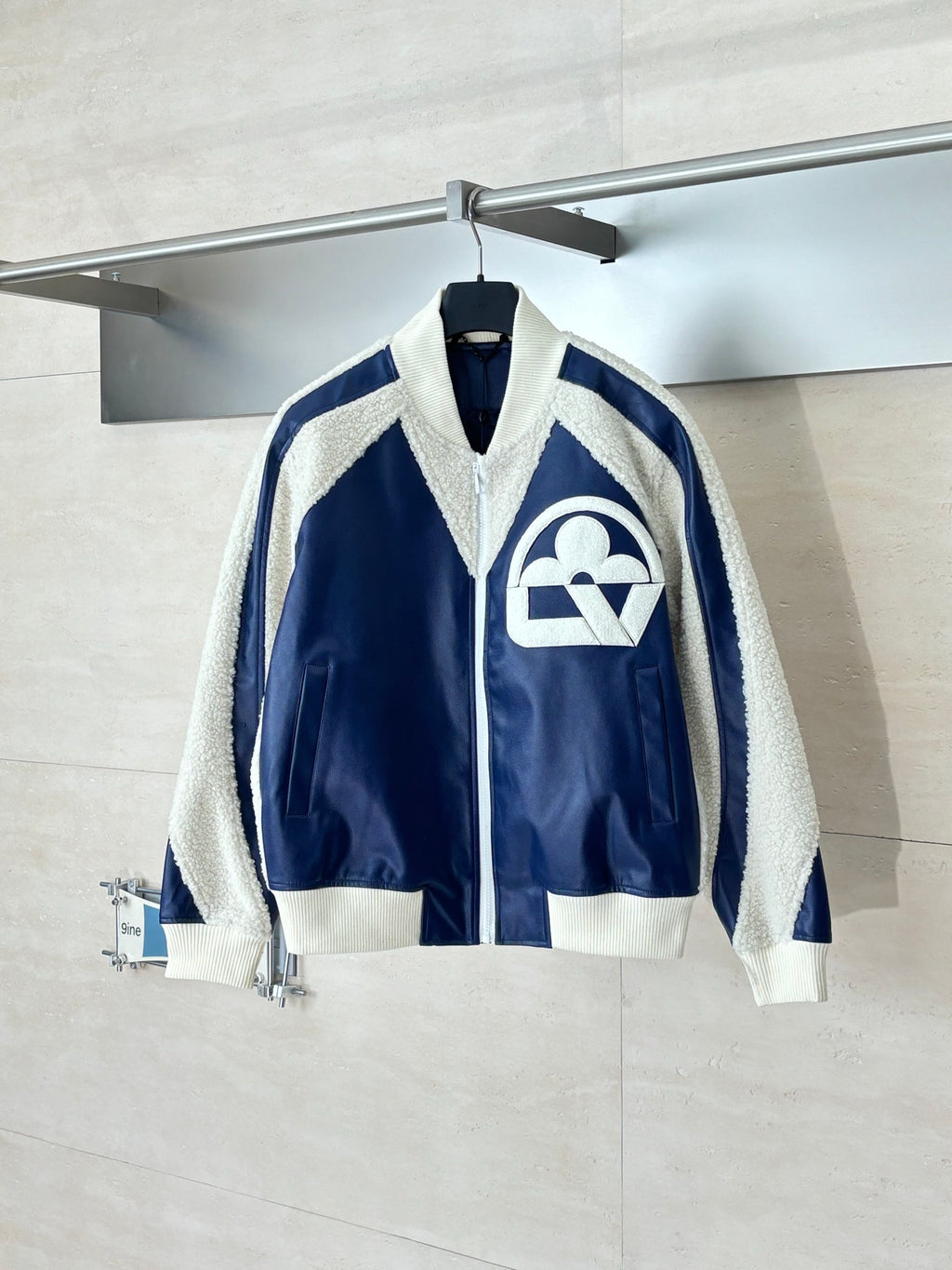 Colorblock sherpa-trim jacket with front zip and large cream logo on navy