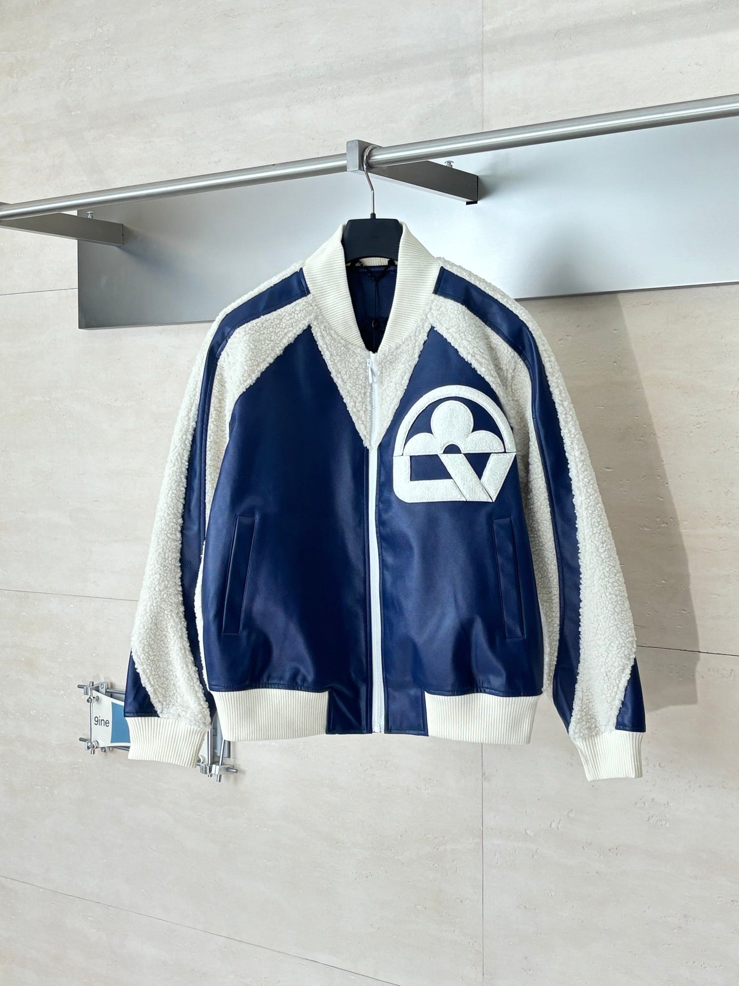 Colorblock sherpa-trim jacket with front zip and large cream logo on navy