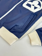 Close-up of navy jacket with cream ribbed cuffs and hem, sherpa-lined edges
