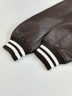 Louis Vuitton varsity jacket sleeves, dark leather with black-and-white striped ribbed cuffs