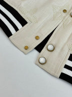 Louis Vuitton varsity jacket sleeve cuff, cream fabric with gold buttons and striped ribbing