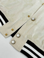 Louis Vuitton varsity jacket cuff buttons, cream fabric with black-and-white striped trim