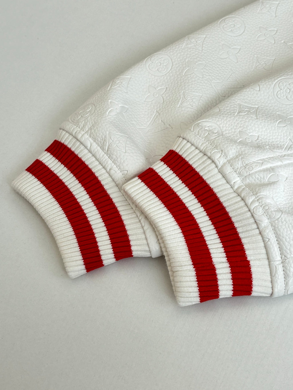 Long-sleeve top cuffs: white ribbed knit with red-and-white striped trim