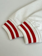 Long-sleeve top cuffs: white ribbed knit with red-and-white striped trim