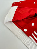 Red and white varsity jacket with snap buttons and ribbed white sleeve trim
