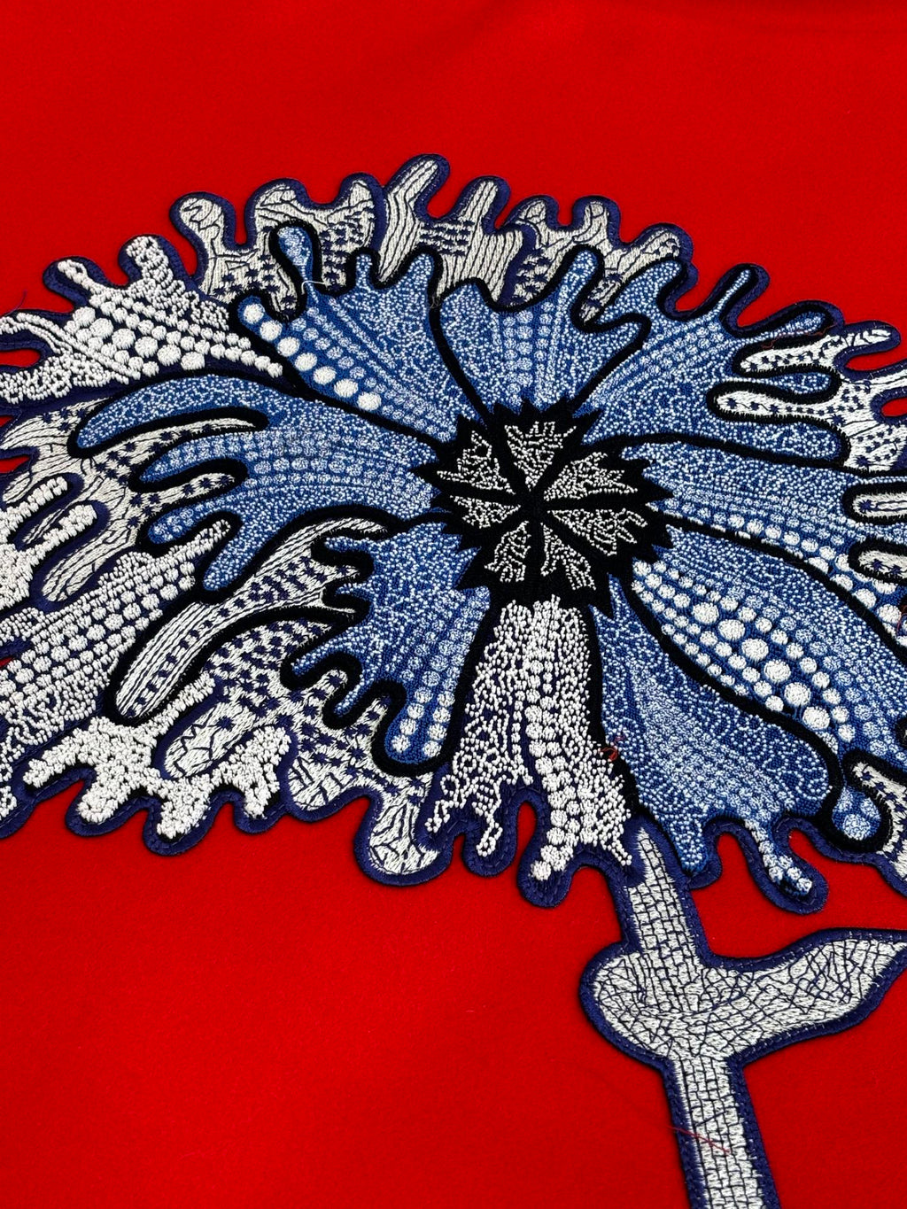 Long-sleeve top with large blue-gray snowflake embroidery on red fabric