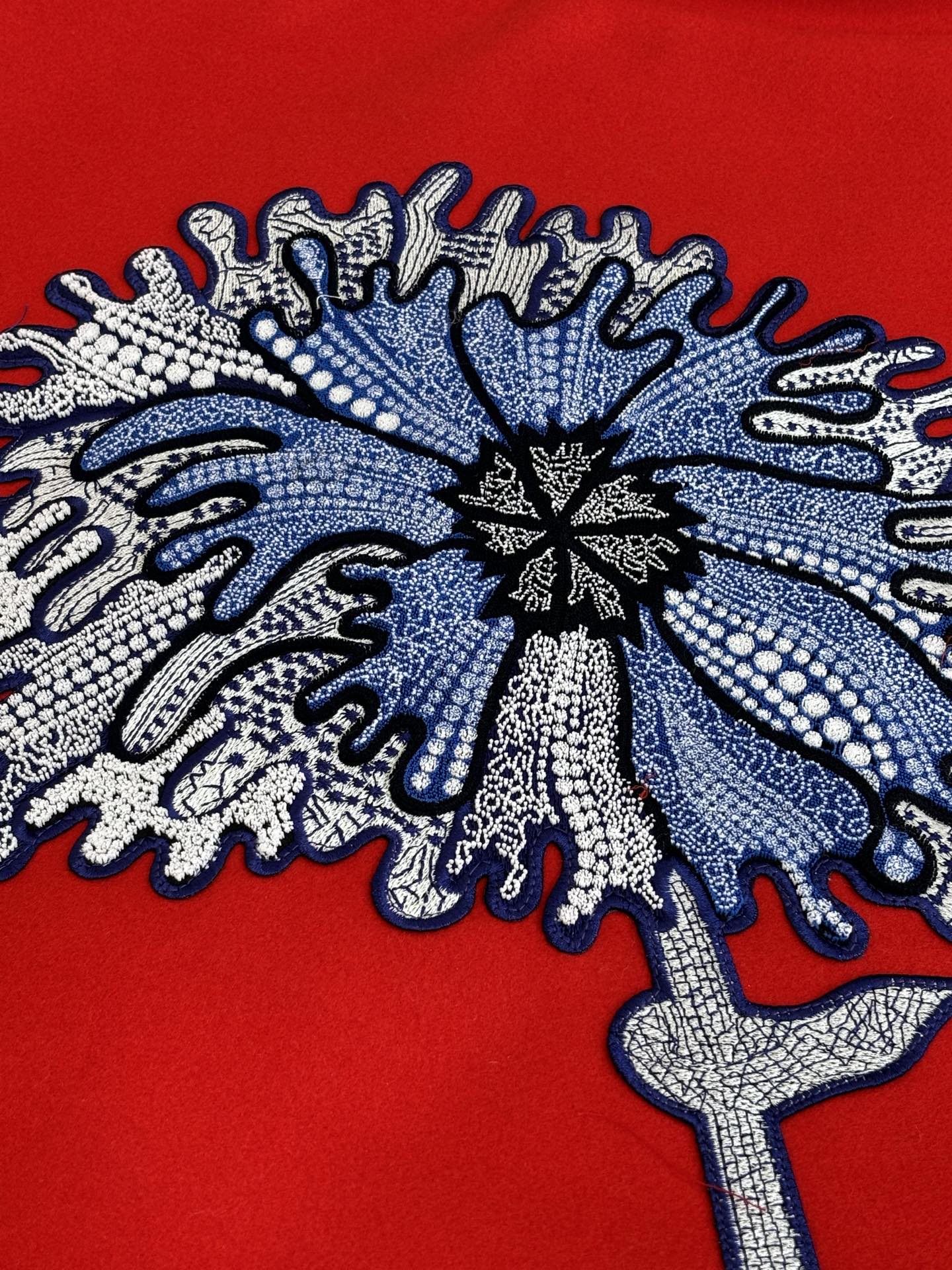 Long-sleeve top with large blue-gray snowflake embroidery on red fabric