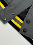 Louis Vuitton bomber jacket collar and button placket with yellow-and-black striped knit cuffs