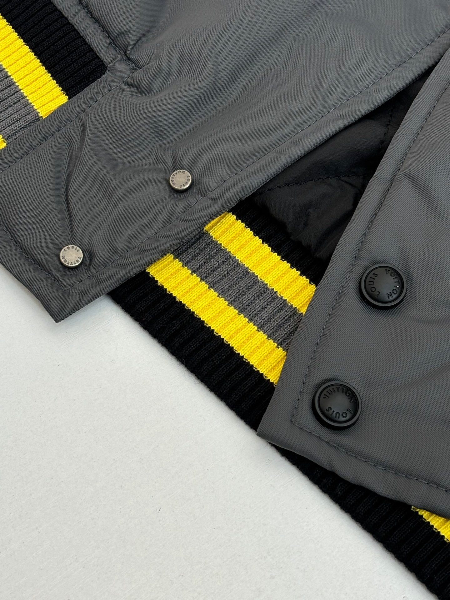 Louis Vuitton bomber jacket collar and button placket with yellow-and-black striped knit cuffs