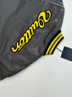 Louis Vuitton bomber jacket side view with yellow logo lettering and ribbed striped trim