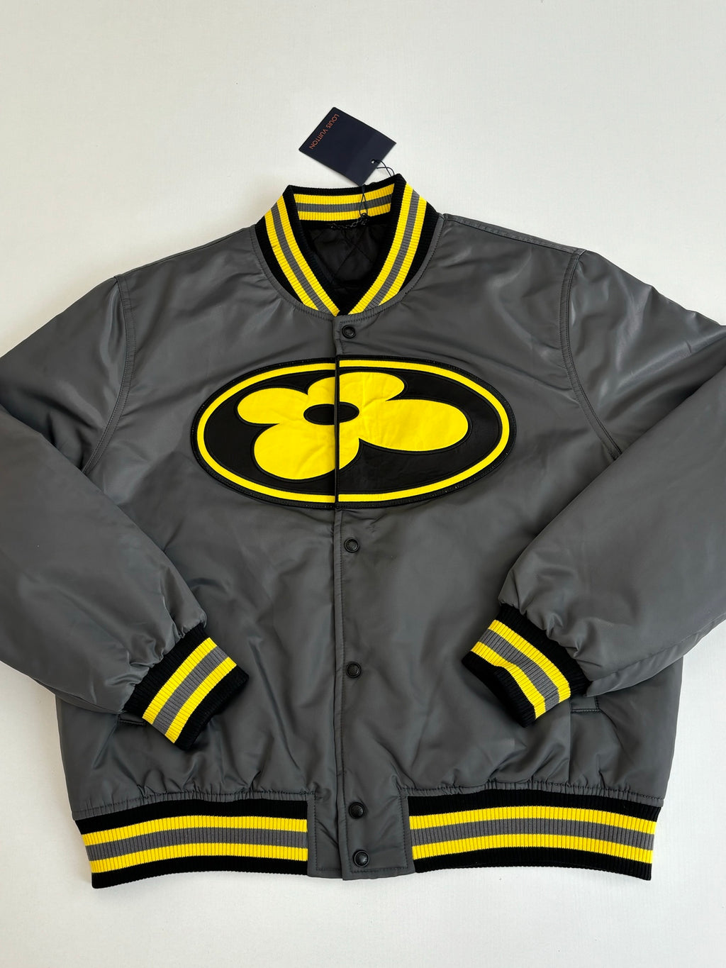 Louis Vuitton bomber jacket in dark gray with yellow logo patch and striped ribbed trim