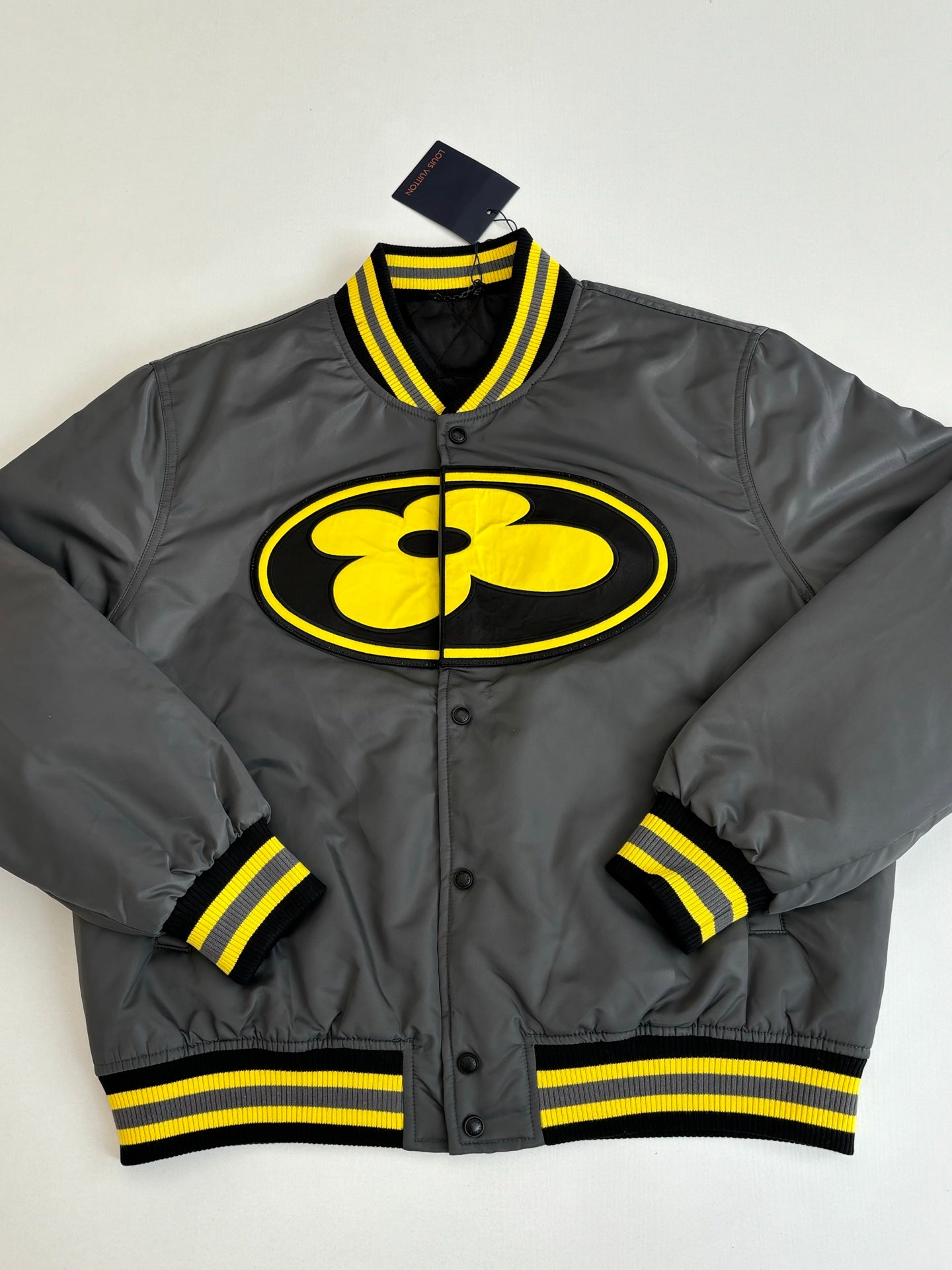 Louis Vuitton bomber jacket in dark gray with yellow logo patch and striped ribbed trim