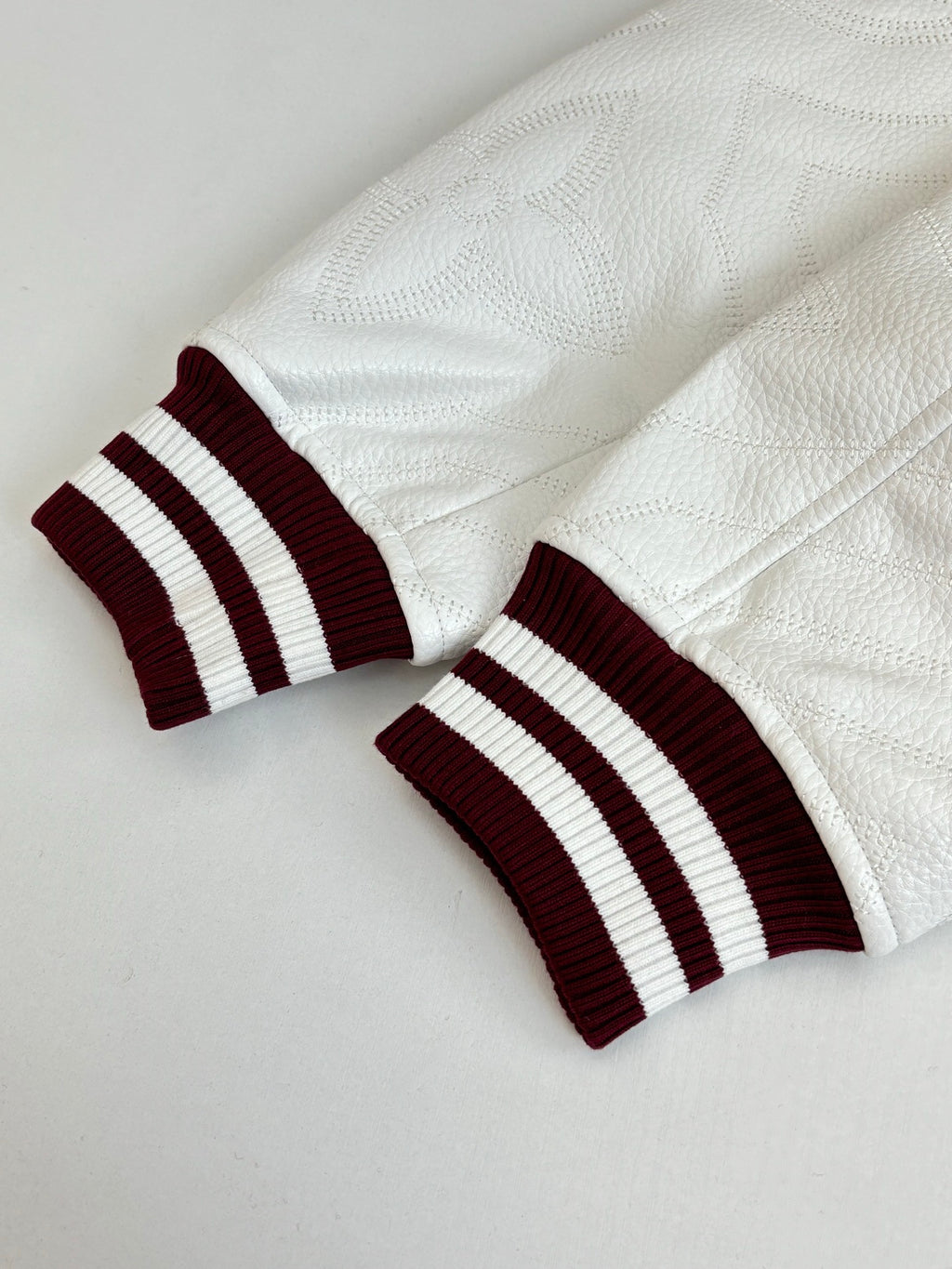 Close-up of ribbed cuff: burgundy with two white-and-black striped bands