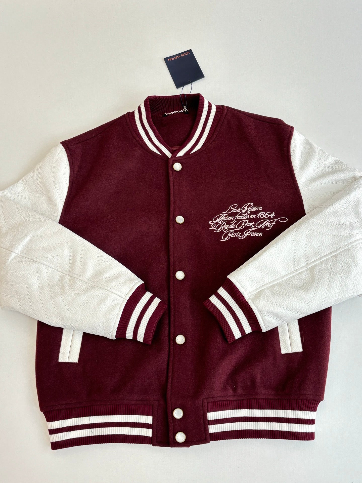 Burgundy and white varsity jacket with button placket, striped collar and cuffs, front logo