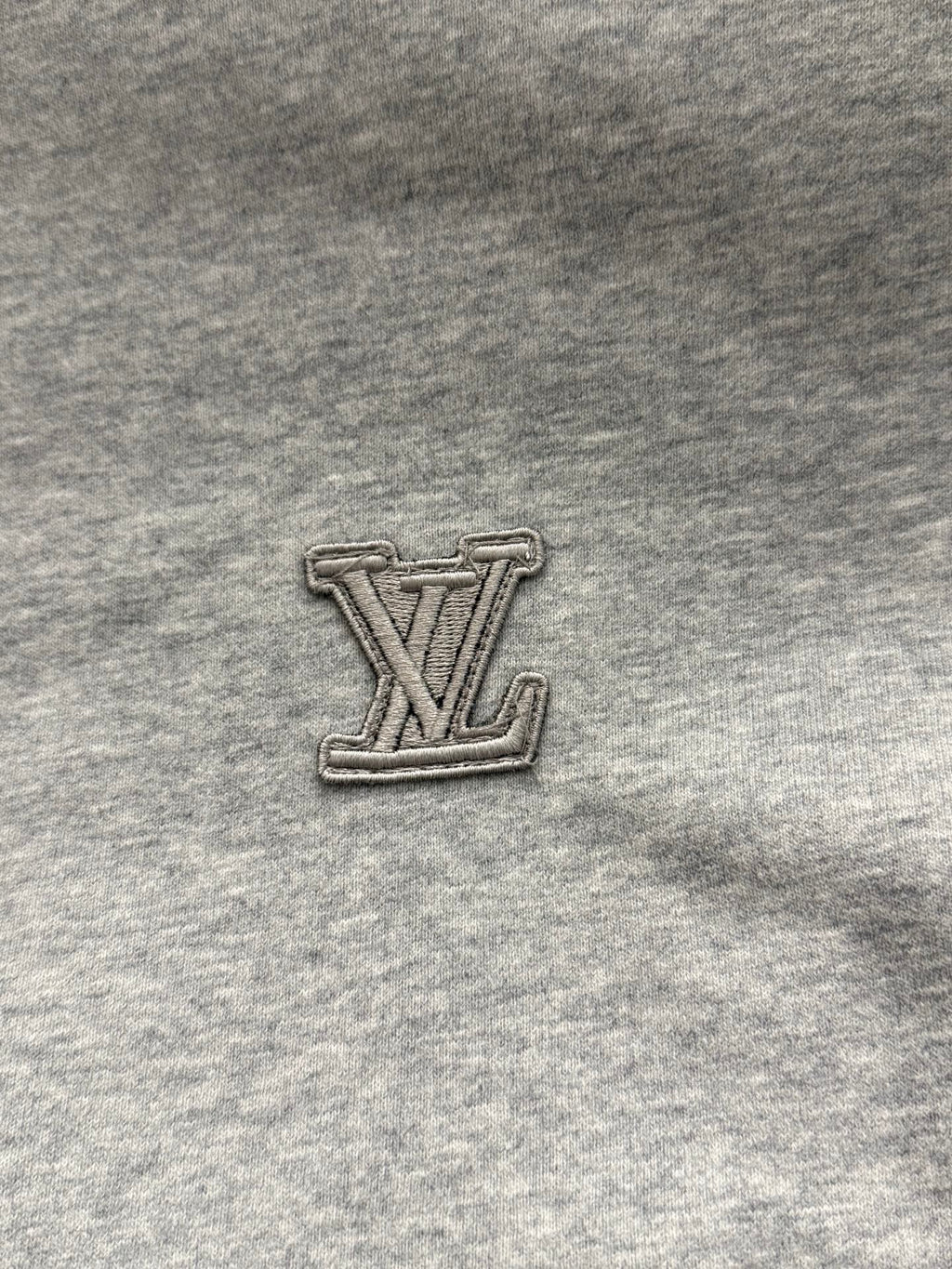 Louis Vuitton LV logo patch on gray hoodie fabric