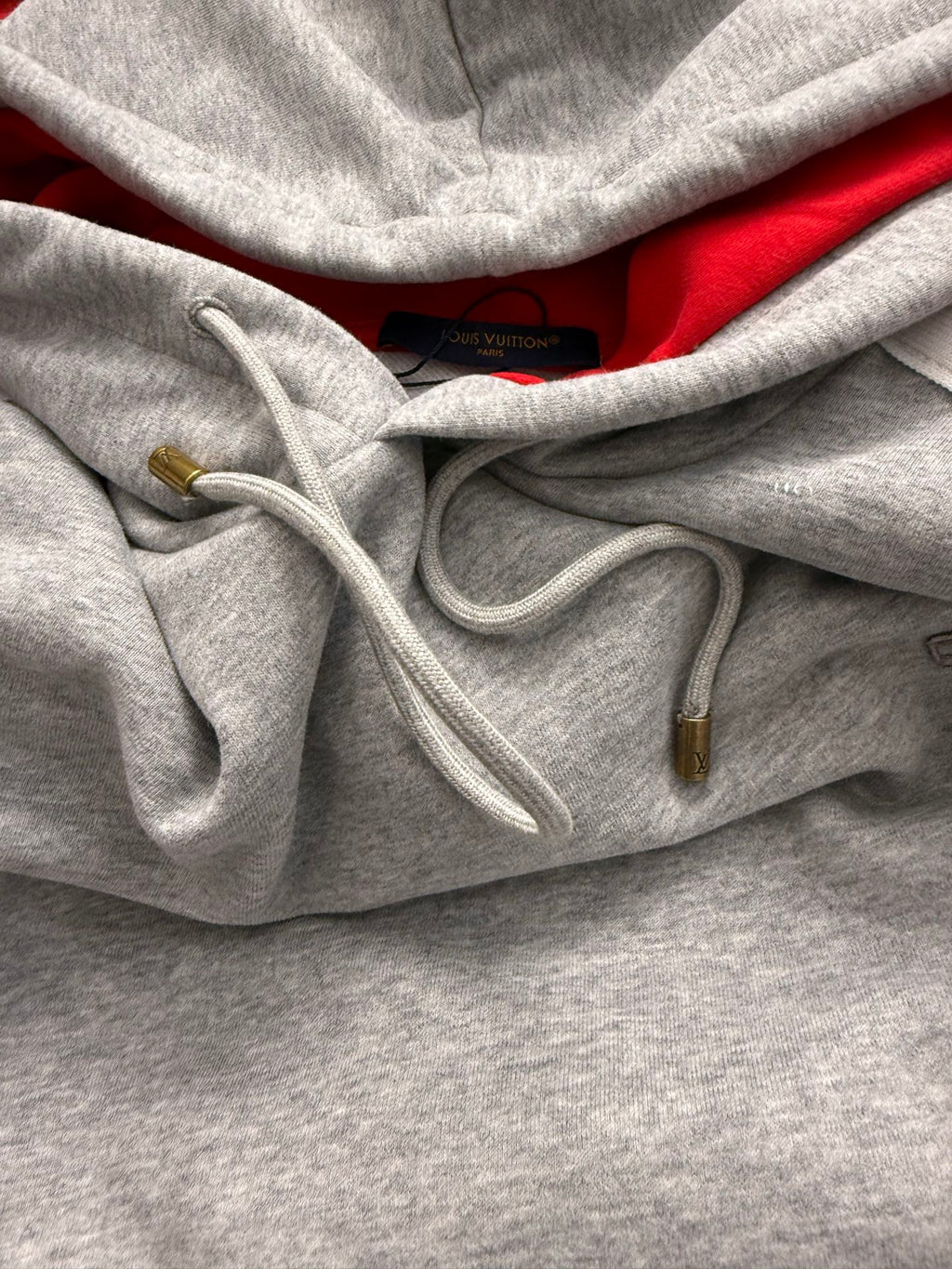Gray hoodie front with red interior lining and white drawstrings