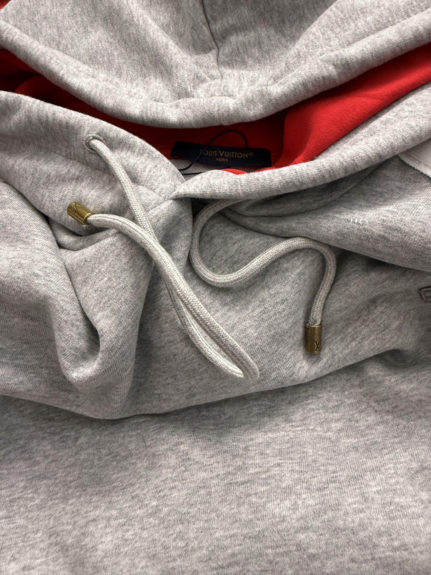 Gray hoodie front with red interior lining and white drawstrings