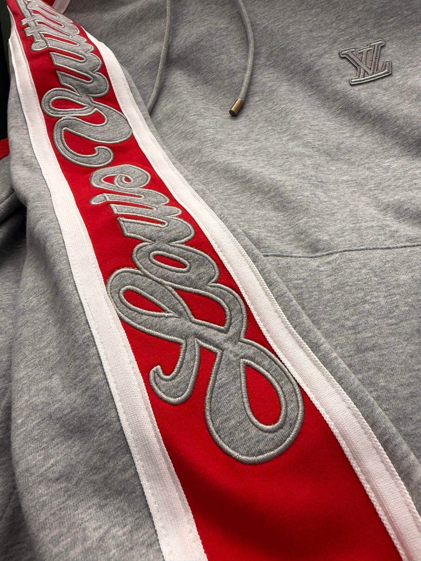 Gray hoodie side stripe with red panel and stylized lettering
