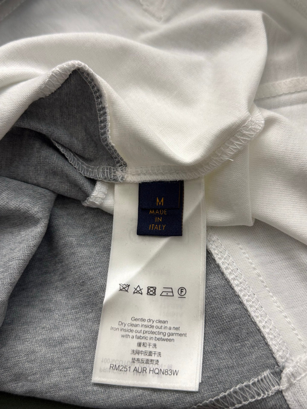 Clothing care label inside collar with washing icons and size information