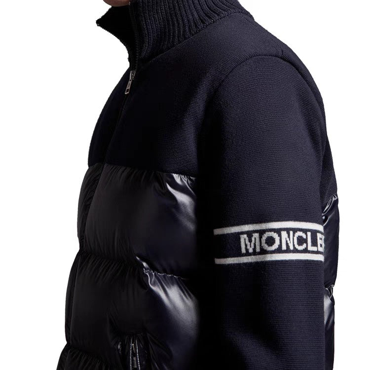 Moncler puffer jacket with navy knit sleeves, black quilted body, stripe logo