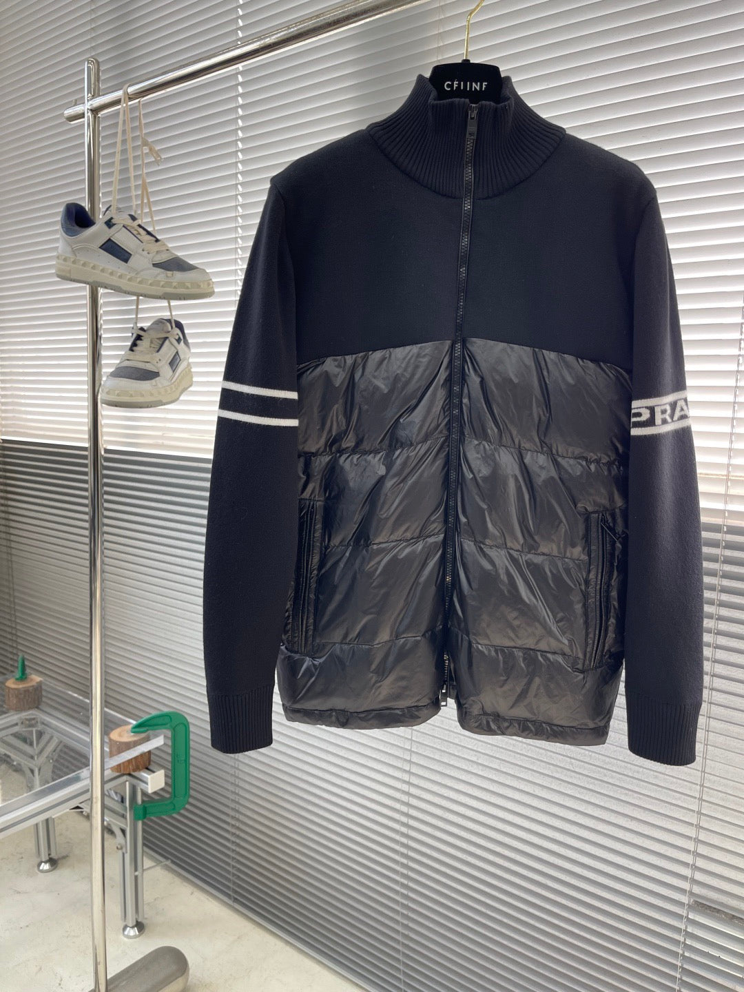Moncler puffer jacket with navy knit collar and shiny black quilted front, stripe detail