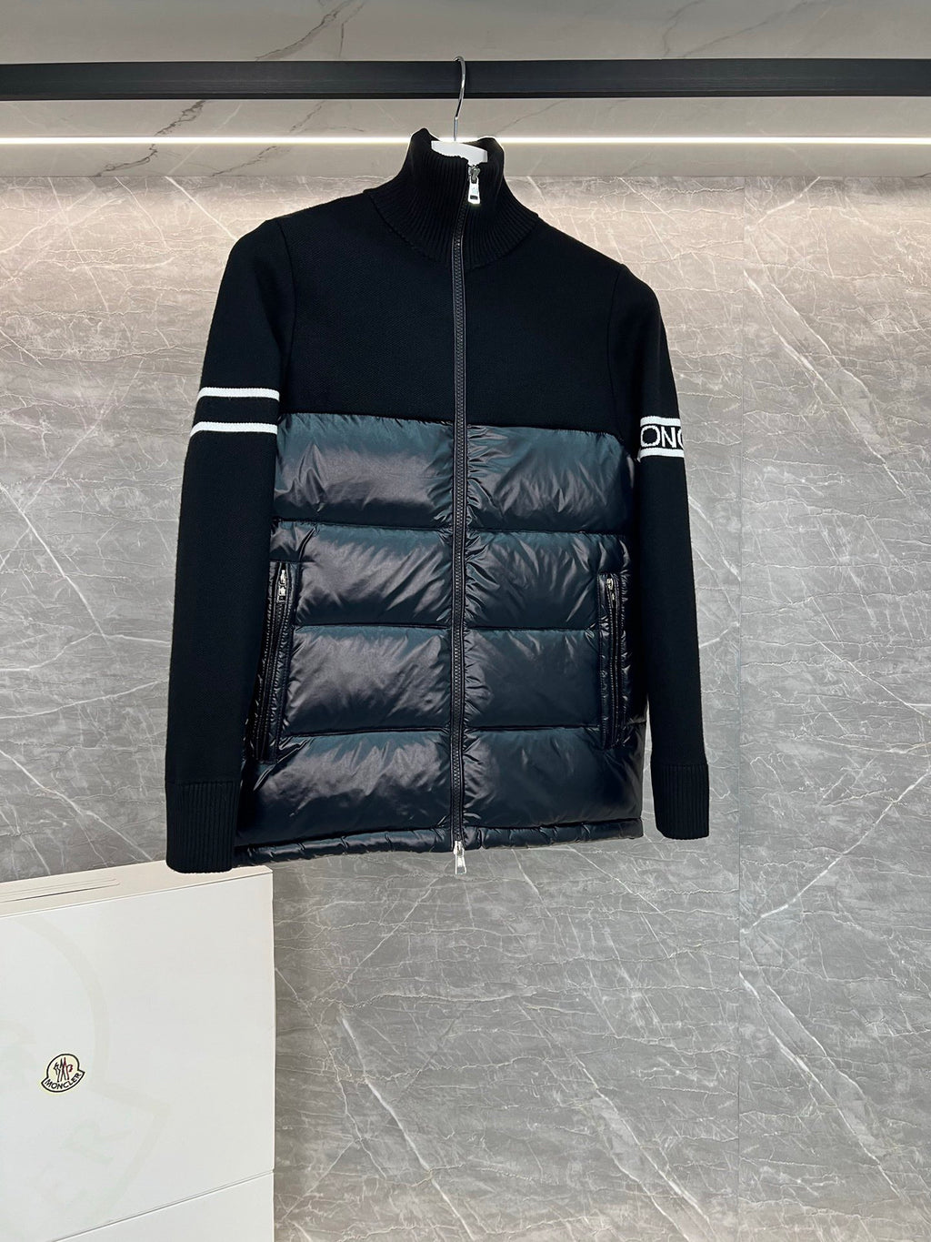 Moncler quilted puffer jacket with black knit sleeves and striped arm bands