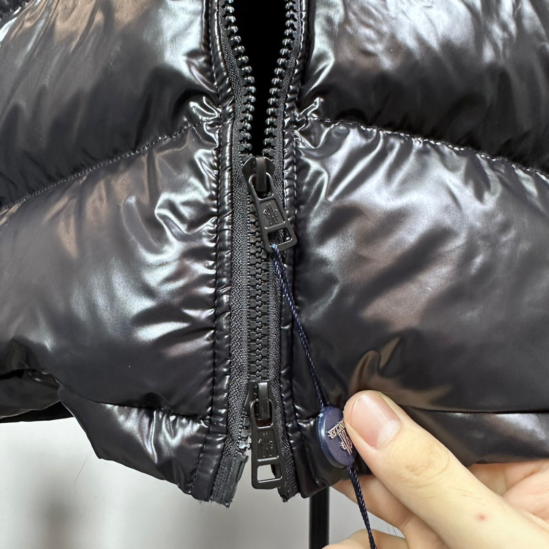 Front zipper and glossy quilted panels on down puffer jacket, close-up