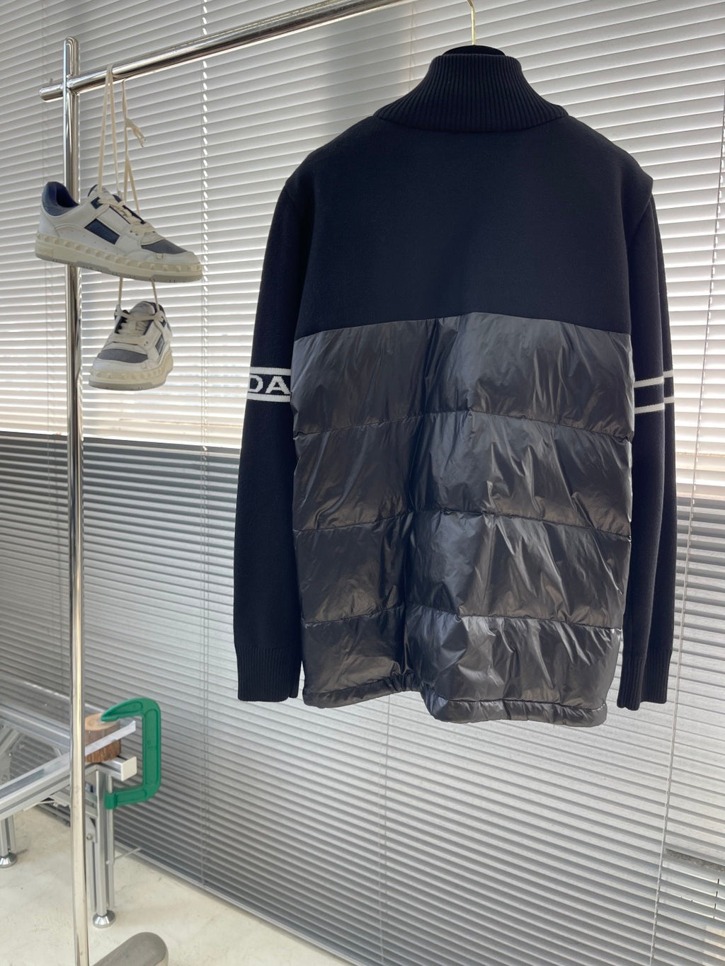 Moncler puffer jacket back view with navy knit upper and shiny black quilted lower