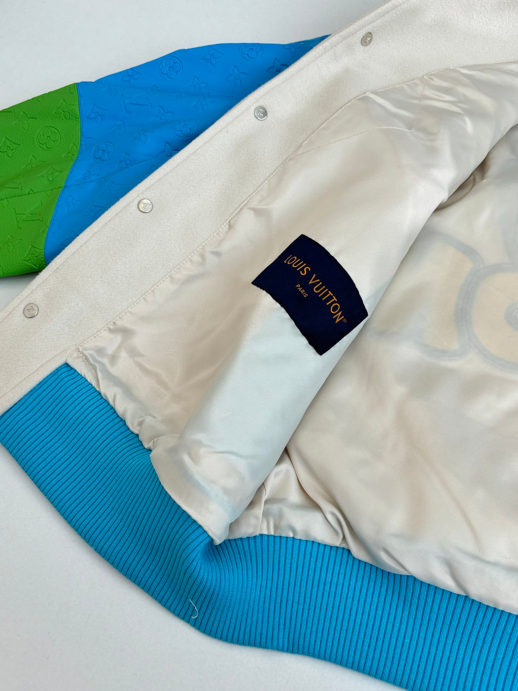 Louis Vuitton button-up jacket neckline and inner label with blue ribbed trim at cuff