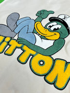 Louis Vuitton chest graphic on cream: smiling cartoon character with green hat and blue arms