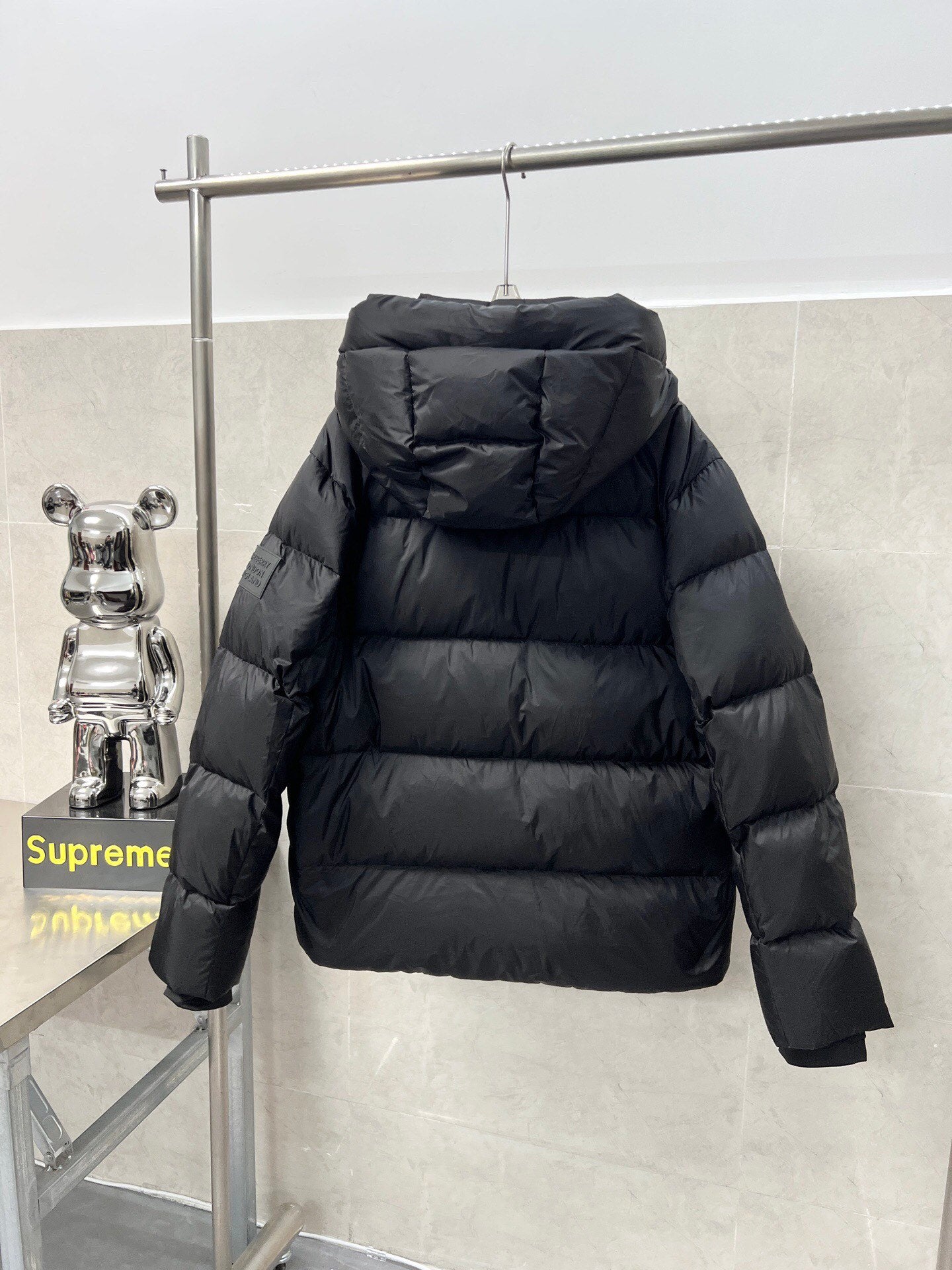 Long hooded puffer jacket, dark color, back view with padded hood
